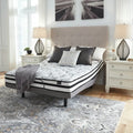 Ashley Chime innerspring mattress on an adjustable bed frame in a bright, modern bedroom.