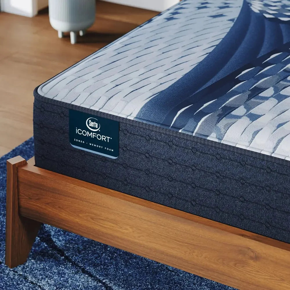 Close-up of the Serta iComfort Iona branding on a navy blue textured mattress side panel.

