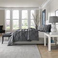 Side angle of the plush charcoal SleepTone pinch pleat comforter showing luxurious loft and drape.

