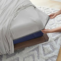 Hands securing a grey Ver-Tex fitted sheet with Powerband technology for a smooth, stay-put fit.
