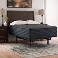 Modern bedroom featuring the Ashley Gray 1200 Hybrid mattress with head elevation, styled with dark wood nightstands and glass lamps.
