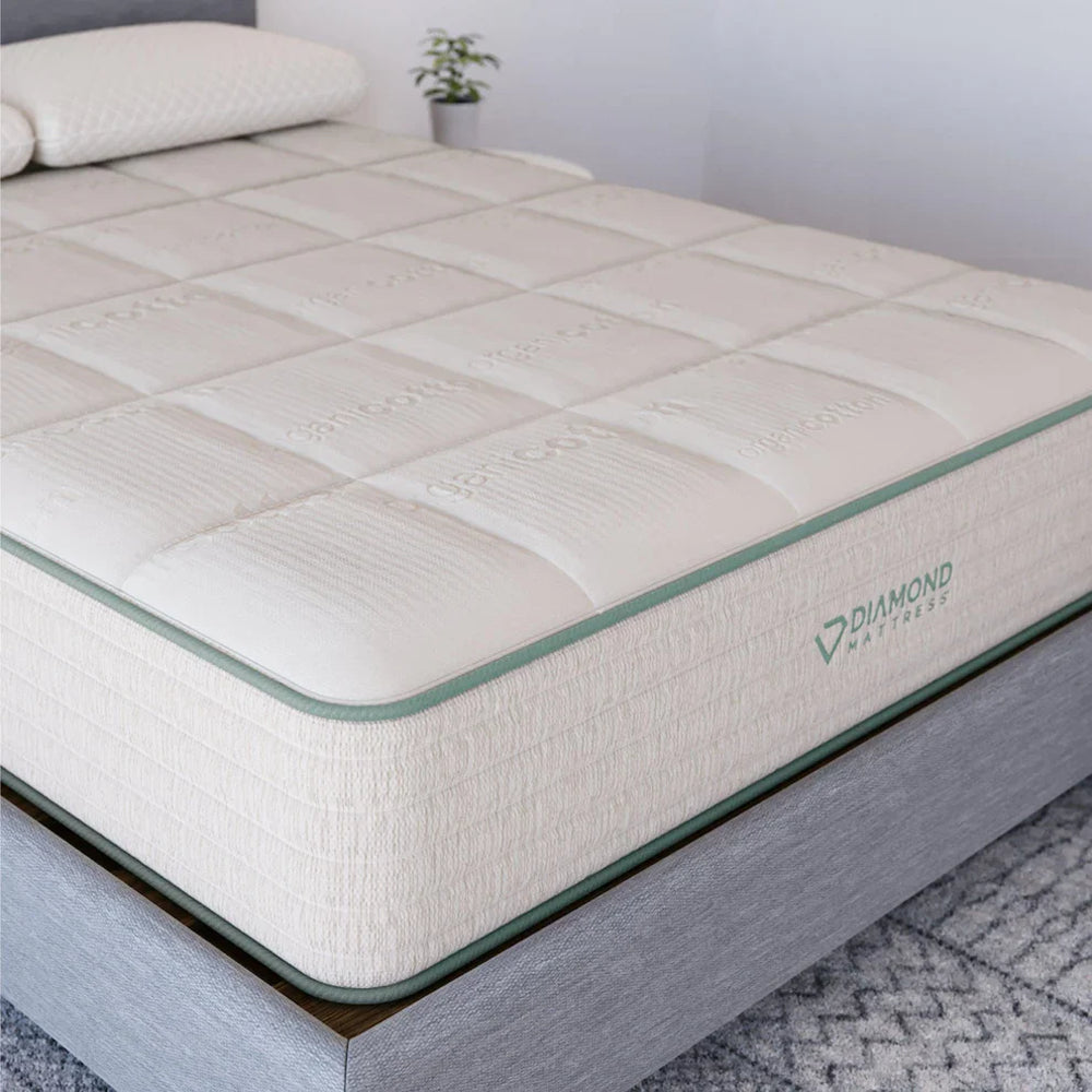 Side profile of the Diamond Mattress Sage Organic Latex hybrid on a grey upholstered bed frame highlighting the breathable organic cotton cover.
