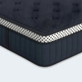Macro view of the navy blue tufted surface of the WinkBeds Blue 15-inch mattress designed for pressure-relieving comfort and airflow.
