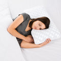 Side sleeper resting on a Malouf shoulder pillow for ergonomic neck alignment and cooling comfort.
