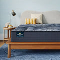 Side view of Serta Perfect Sleeper X Kendall 13 Inch Mattress on a wood frame in a stylish room.
