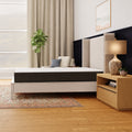 Side profile of the Rose 10-inch mattress by South Bay featured in a master bedroom interior with a white wingback headboard and hardwood floors.
