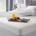 Tray with breakfast on a Malouf HyperChill mattress protector, showing stain-resistant cooling fabric.
