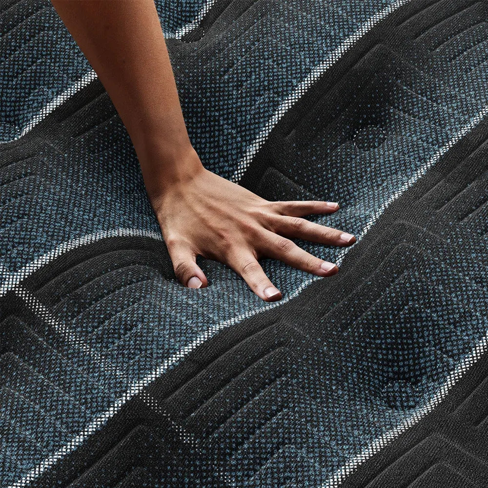 Hand pressing on Beautyrest World Class plush mattress to show responsive contouring and pressure relief.
