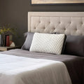 Malouf Quilted Convolution pillow propped against a headboard, offering plush support for side sleepers.
