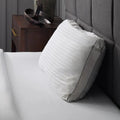 Side profile of the Malouf Z Convolution pillow on a bed, highlighting its high loft for spinal alignment.