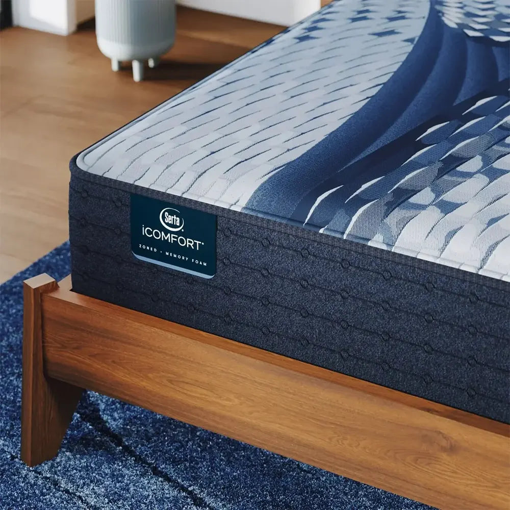 Close-up of Serta iComfort Elana Firm branding on the navy blue quilted side panel of the mattress.
