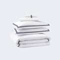 Folded SleepTone navy blue and white hotel luxury bedding set including sheets and duvet cover.
