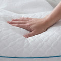 Hand pressing into a Malouf FlexFill pillow to demonstrate plush, responsive shredded foam and fiber support.
