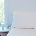 GhostBed Faux Down cooling pillow on a bed, offering luxury comfort and superior neck support.
