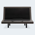 Front-facing view of the Malouf S655 motorized bed base with the head section fully raised and a mattress retainer bar visible.
