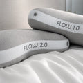 Stacked BEDGEAR Flow 1.0 and 2.0 pillows highlighting the breathable white mesh band and supportive lofts.