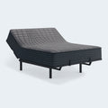 Gray 1200 Hybrid firm mattress with the head section elevated on an adjustable power base, showcasing flexible hybrid construction.
