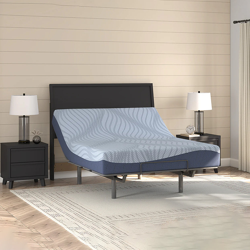 Modern bedroom interior featuring the Ashley Peak 2.0 10-inch mattress styled on a black platform bed frame with minimalist wooden furniture.
