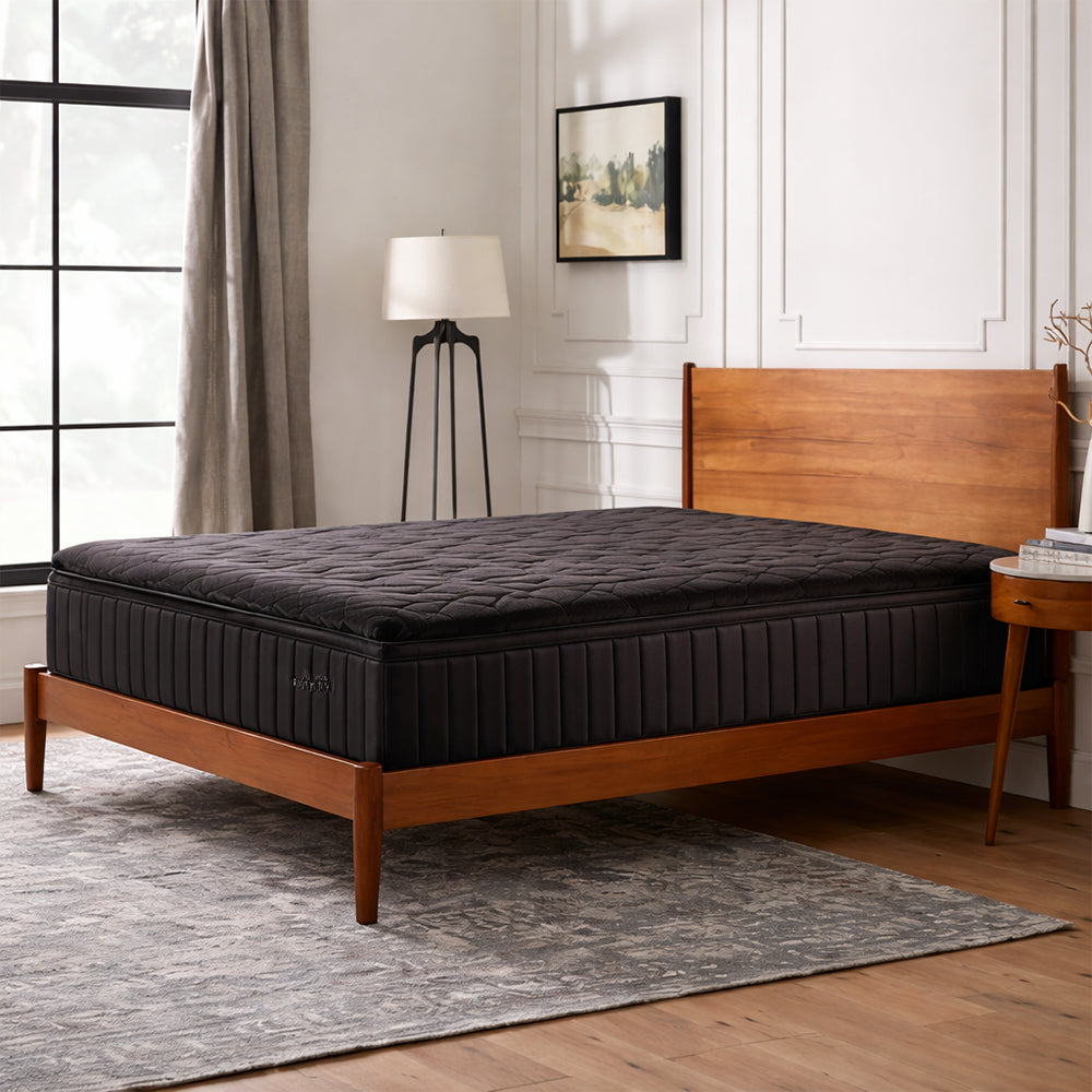 Malouf Neve 12-inch all-foam mattress with a textured charcoal grey top styled on a mid-century modern wooden platform bed frame.
