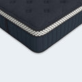 Detailed close-up of the WinkBeds Blue mattress corner showcasing the white polka-dot reinforced tape edge and breathable navy quilted fabric.
