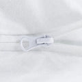 Close-up of the secure zippered closure on a white Malouf Prime pillow protector.

