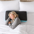 Woman sleeping on a Malouf Ice Cloud pillow with Omniphase cooling cover for temperature-regulated rest.
