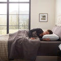 Woman using a Malouf FlexFill cooling pillow for comfortable, temperature-regulated side sleeping.
