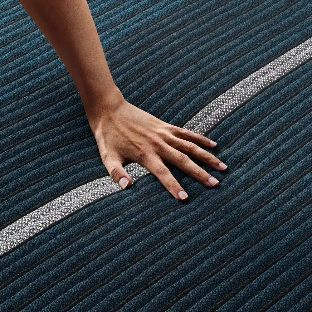 Hand pressing on the Beautyrest World Class Hybrid mattress to demonstrate responsive pressure relief.
