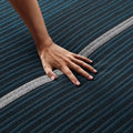 Hand pressing on the Beautyrest World Class Hybrid mattress to demonstrate responsive pressure relief.
