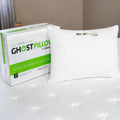 GhostPillow shredded cluster pillow next to its retail box on a white mattress for luxury sleep setup.
