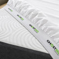 Wide GhostGrip elastic band on a white GhostSheet fitted tightly around a mattress corner to prevent slipping.
