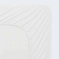 Universal Fit elastic skirt on a Malouf mattress protector for a snug, secure fit on any mattress depth.

