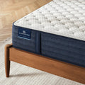 Branding and navy blue quilted texture on the side of a Serta iComfortPRO Chelsea 12 inch medium mattress.
