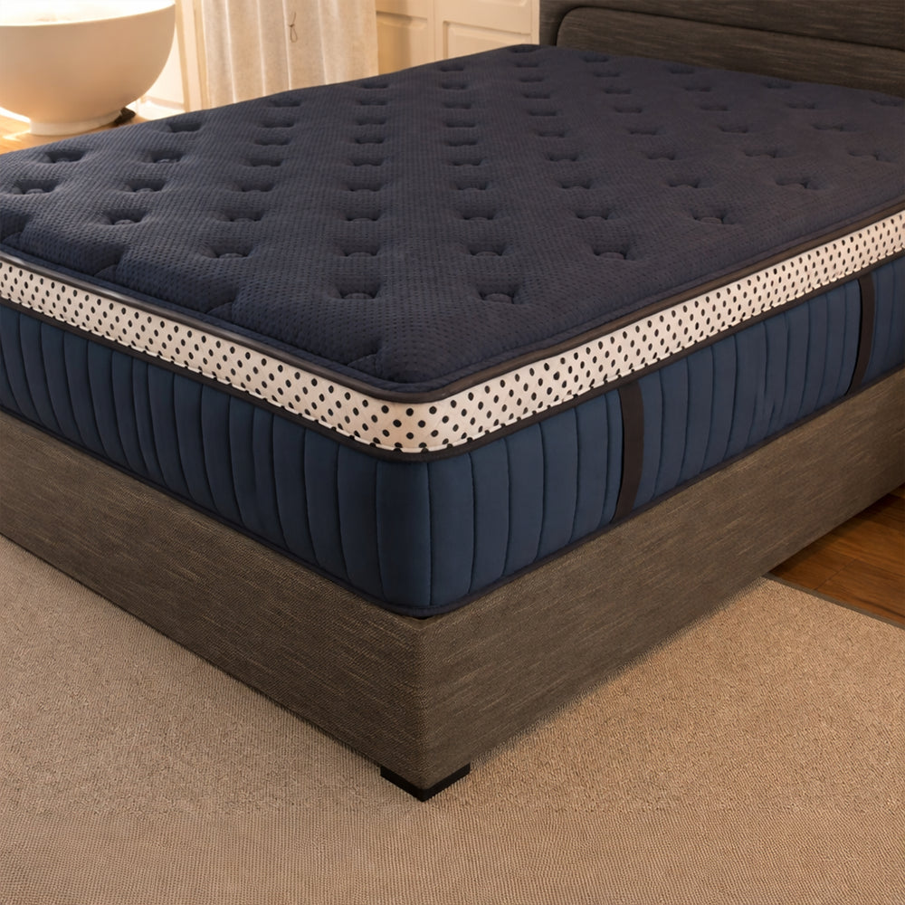WinkBeds Blue 15-inch luxury firm mattress styled on a natural wooden platform bed frame in a bright modern room.
