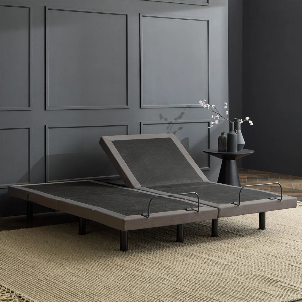Two Malouf S655 adjustable foundations in a neutral flat position, showing the low-profile design and grey upholstered frame.
