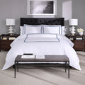 Front view of SleepTone Hotel Luxury white bedding set with navy blue double-stripe detailing.
