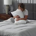 Woman hugging a plush Malouf Gel Convolution pillow, demonstrating its cozy and adjustable comfort.
