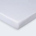 Close-up of a white moisture-wicking performance crib sheet corner for a secure mattress fit.

