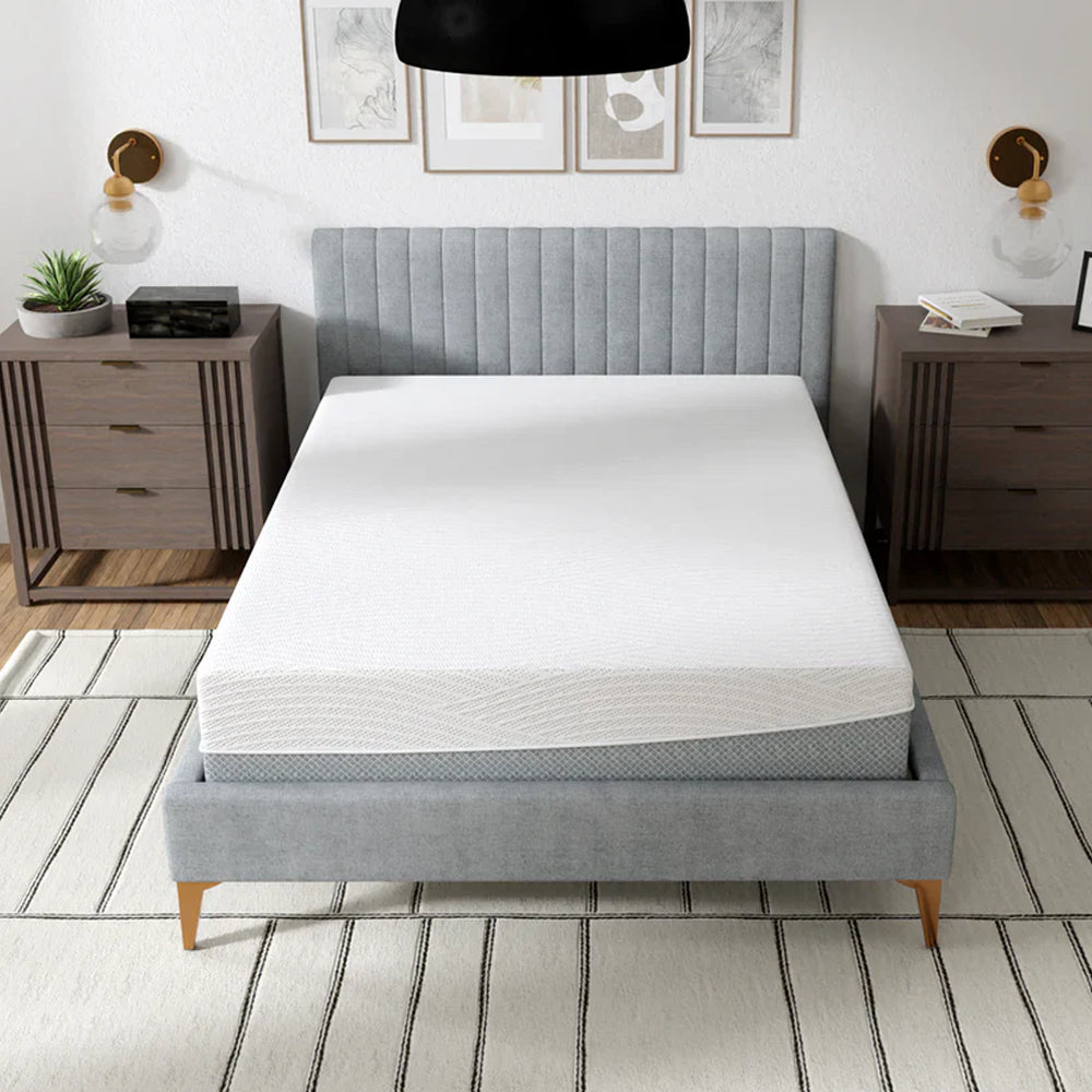 High-angle view of the EcoCore Hybrid Deluxe medium plush mattress on a designer platform bed in a bright, modern master bedroom.
