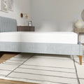 Side view of the EcoCore Origin mattress on a grey platform bed highlighting its firm support and modern low-profile aesthetic.
