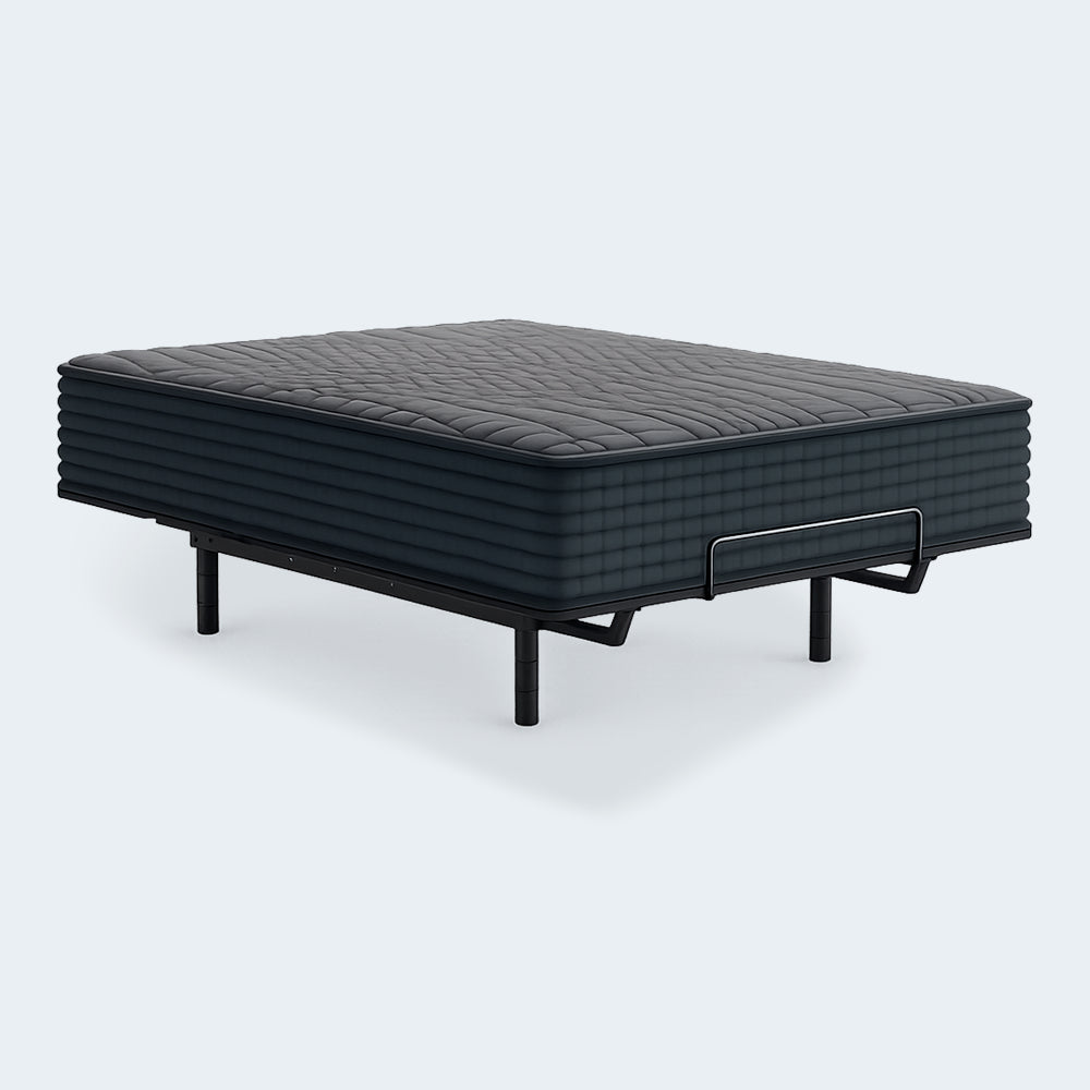 Side view of the Ashley Gray 1200 Hybrid firm mattress on a black metal adjustable power base with a mattress retainer bar.
