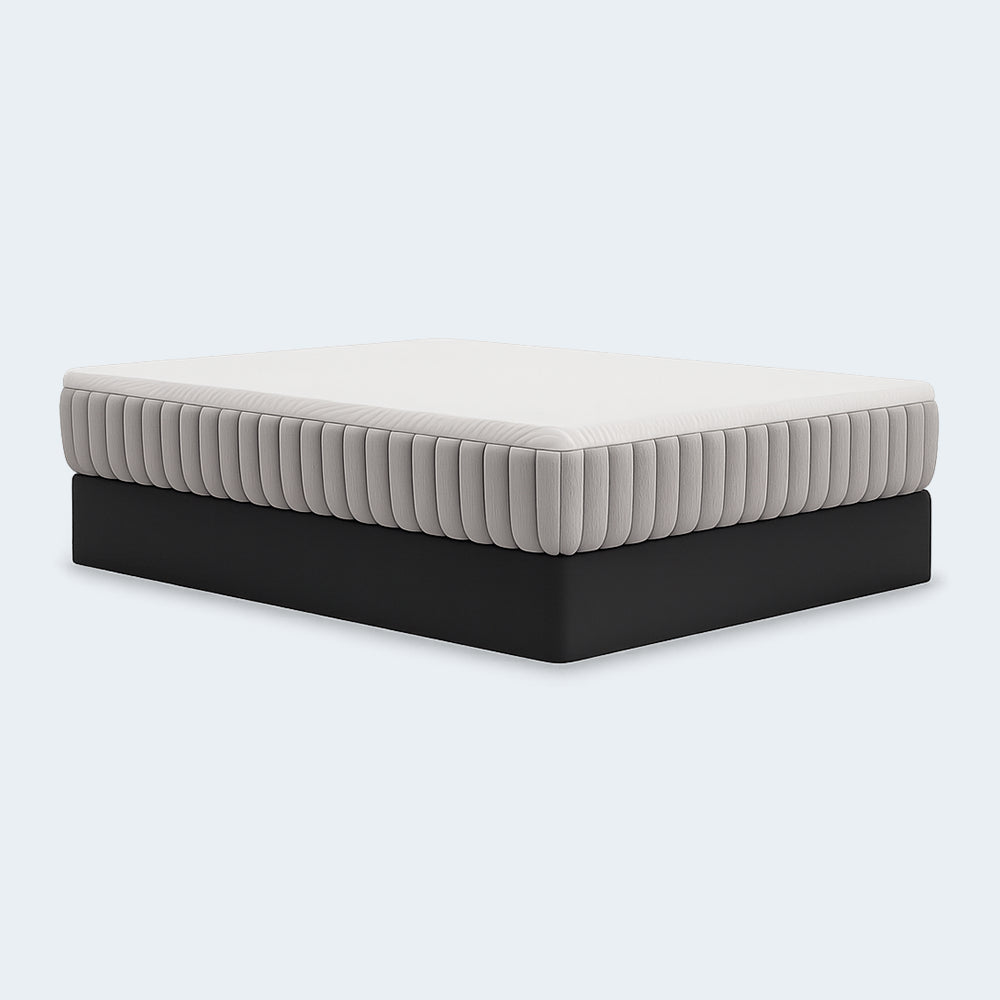 Side-angle perspective of the Terra Sleep 12-inch Medium Mattress by Ashley featuring a white quilted top and signature grey vertically channeled side panels.
