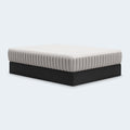 Side-angle perspective of the Terra Sleep 12-inch Medium Mattress by Ashley featuring a white quilted top and signature grey vertically channeled side panels.
