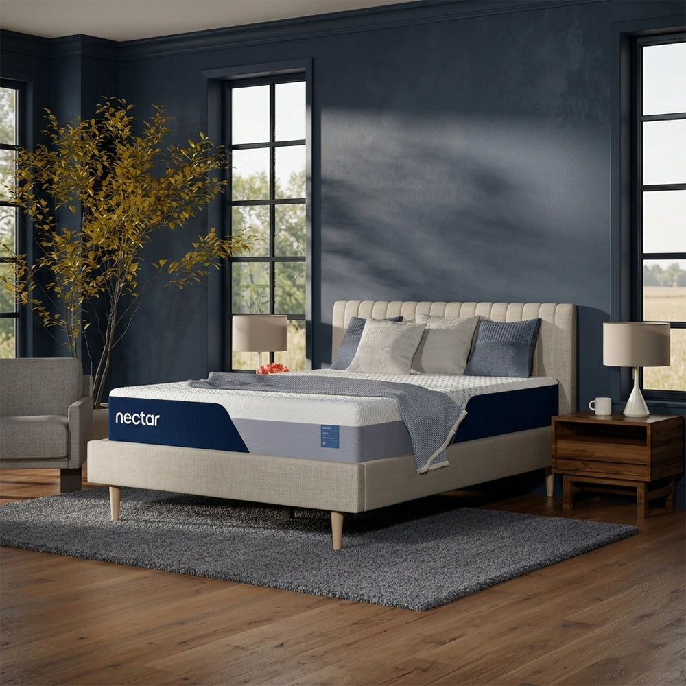 Angled lifestyle shot of the Nectar Classic Firm 12-inch mattress on a contemporary grey upholstered bed frame in a designer master bedroom.
