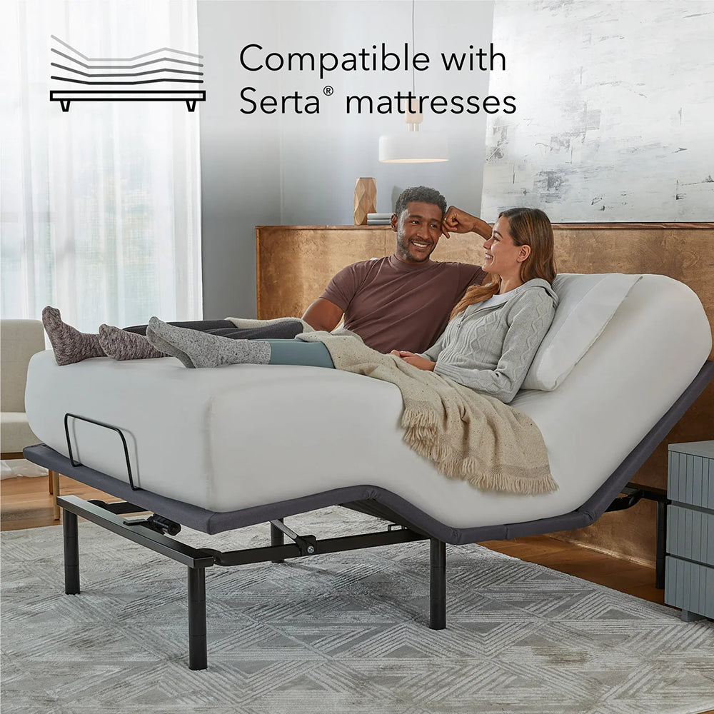 Baselogic Silver adjustable base shown in a bedroom setting highlighting compatibility with Serta and other leading mattress brands.
