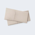 Set of two folded beige BEDGEAR Hyper-Linen pillowcases, providing natural comfort with performance cooling tech.
