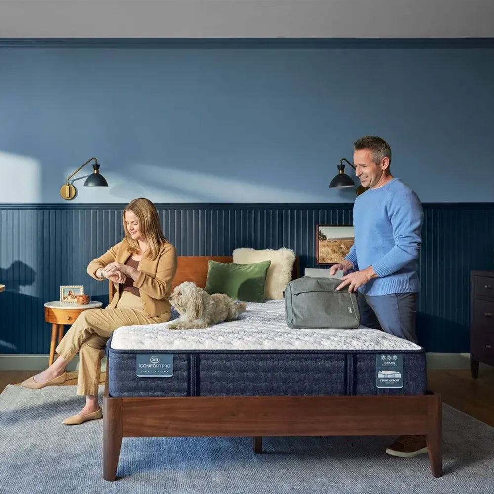 Lifestyle view of a couple enjoying the cooling comfort of a Serta iComfortPro Kingston firm mattress.

