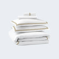 Stacked 6-piece SleepTone Hotel Luxury sheet set in white with premium gold embroidery.
