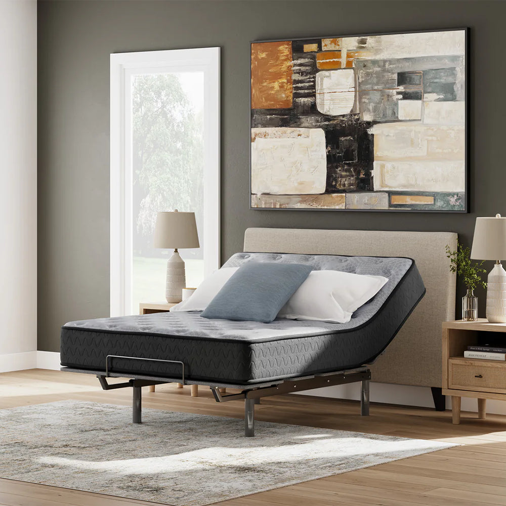 Comfort Plus 10 Inch Medium Mattress styled in a contemporary bedroom on an adjustable base with the head elevated for reading comfort.