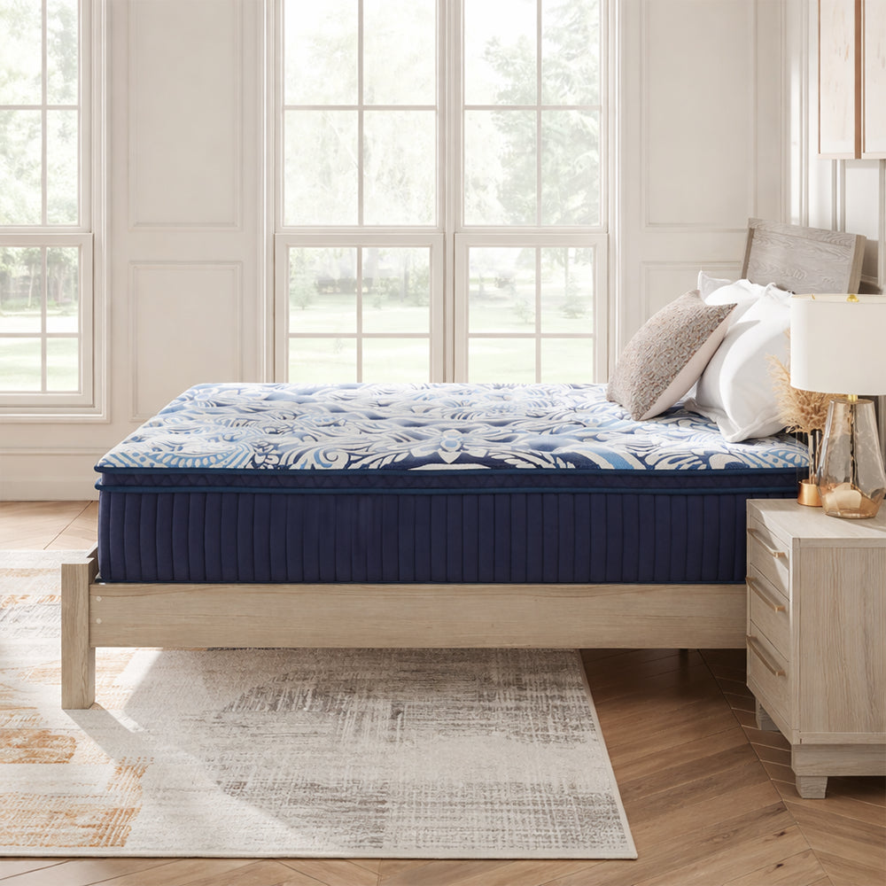 Side profile view of the Ashley Luxe 2.0 Blue 15-inch mattress on a modern wooden bed frame highlighting the deep luxury comfort layers.
